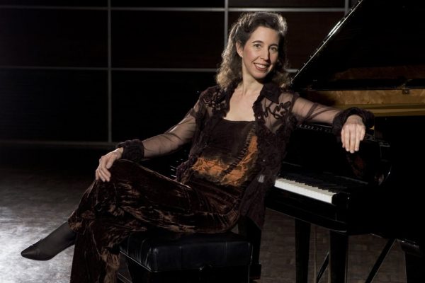 Woman posed in front of piano