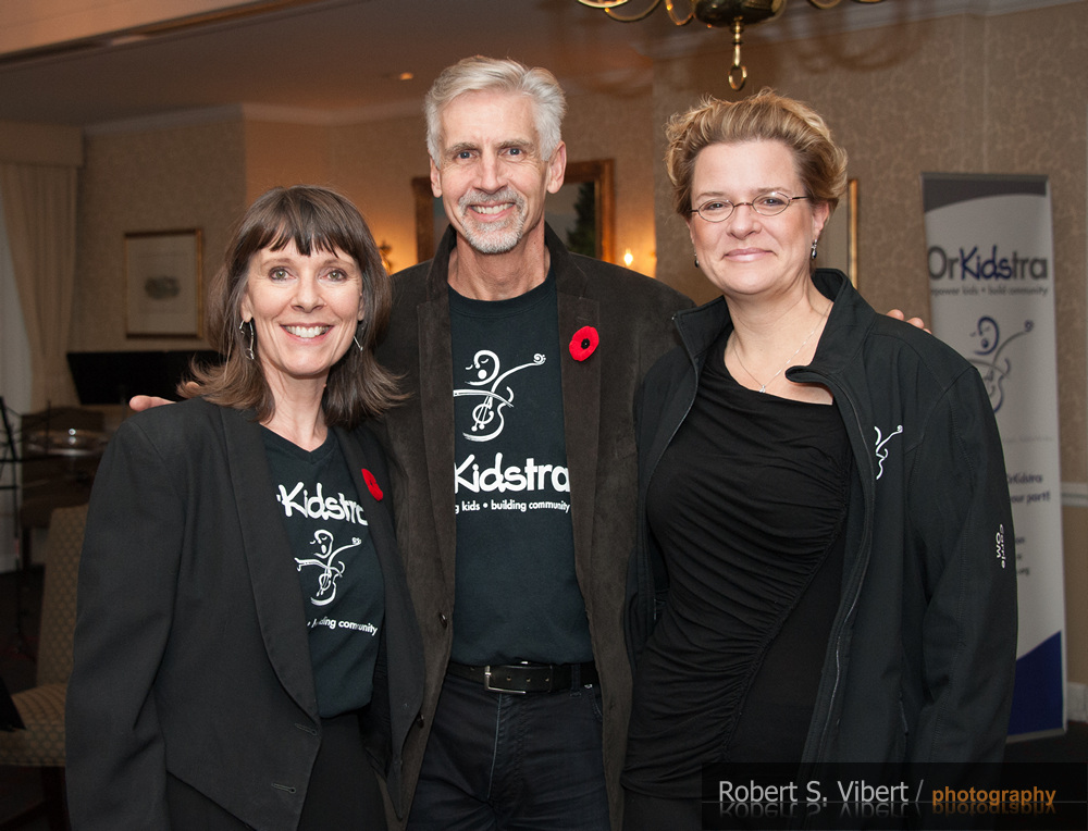A photo of two women and one man smiling at the camera.