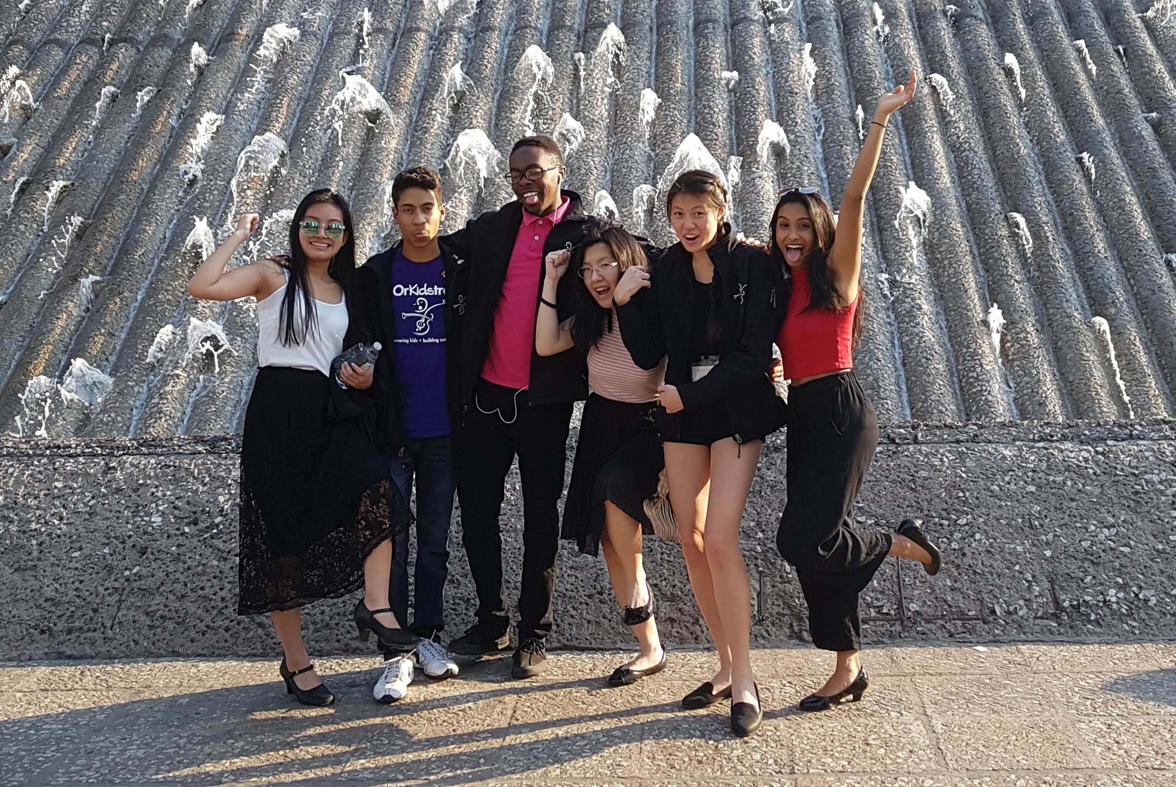 Six OrKidstra students having fun in front of a fountain in Mexico City